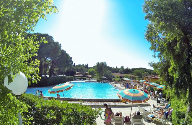 Una piscina con ombrelloni colorati e persone a bordo vasca.