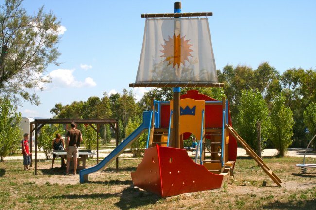Area giochi a forma di nave con scivolo in un parco.