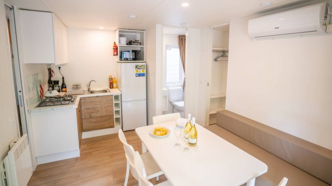 Cucina moderna con tavolo bianco e quattro sedie.