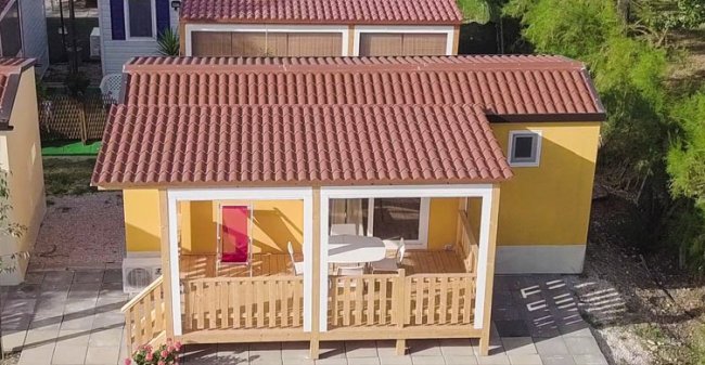 Bungalow giallo con tetto rosso.