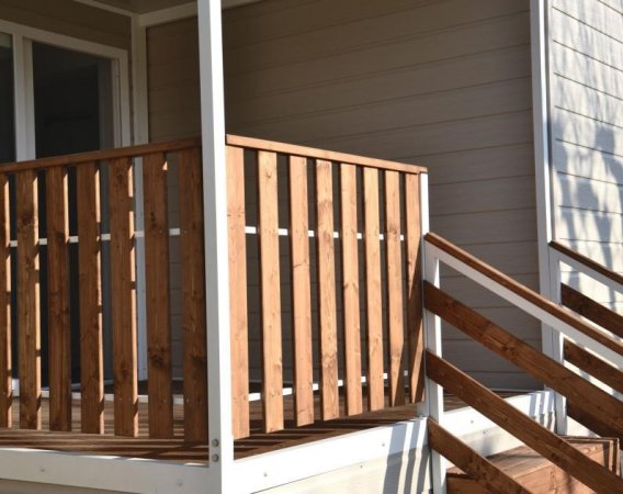 Veranda di legno con ringhiera e scale.