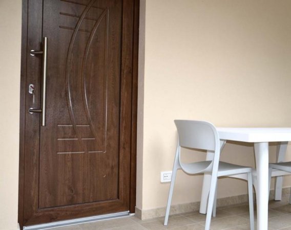 Porta di legno con tavolo e sedia bianchi.