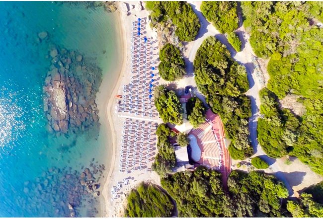 Spiaggia attrezzata vista dall'alto, mare turchese.