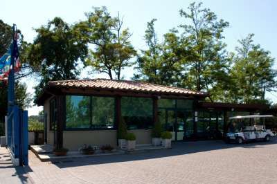 Edificio con vetrate e tetto in tegole, circondato da alberi.