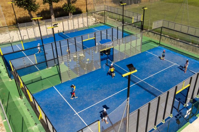 Campi da paddle blu con persone che giocano.