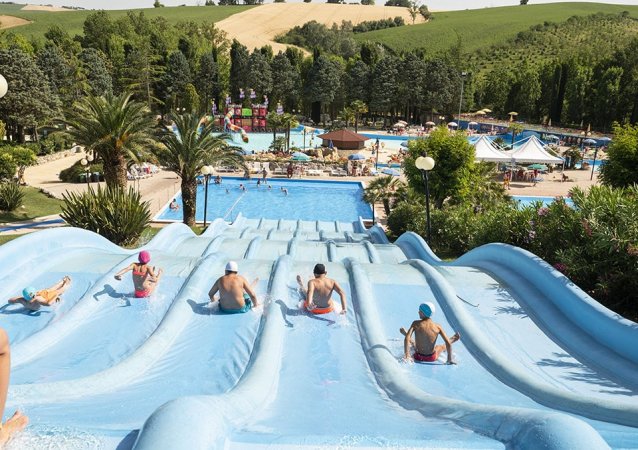 Persone su grandi scivoli d'acqua in un parco acquatico.