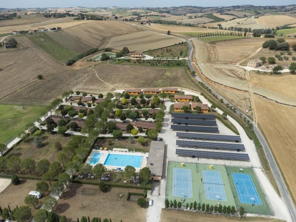 Vista dall'alto di piscine e campi da tennis in campagna.