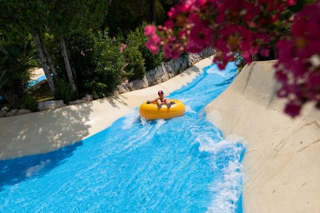 Persona su un gonfiabile giallo in uno scivolo d'acqua.