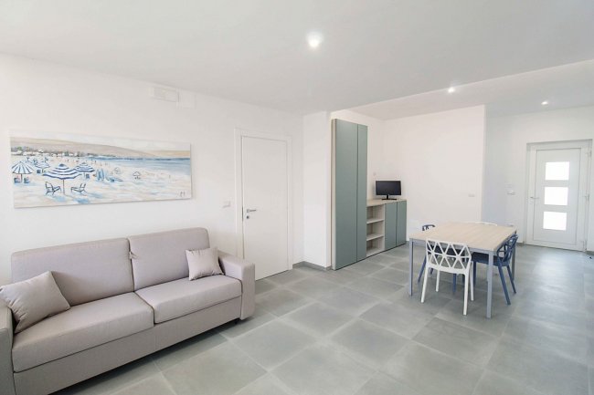 Soggiorno moderno con divano, tavolo e sedie.