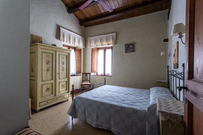 Camera da letto con armadio antico e letto matrimoniale.