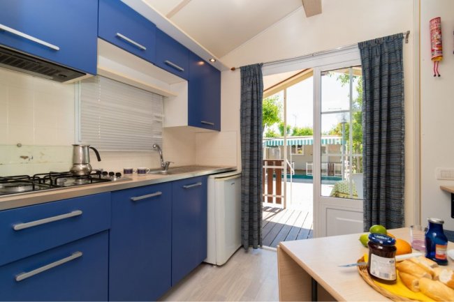 Cucina luminosa con porte finestra.