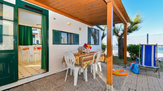 Veranda con tavolo e sedie vicino al mare.