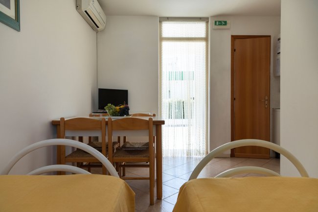 Camera con due letti, tavolo e TV.