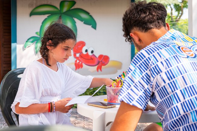 Due bambini che colorano insieme a un tavolo.