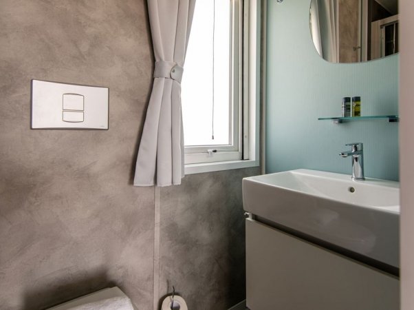Bagno moderno con lavabo e finestra.