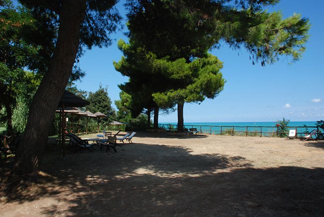 Area ombreggiata con sdraio e vista mare.