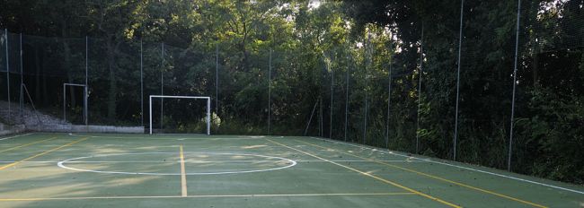 Un campo sportivo all'aperto circondato da alberi.