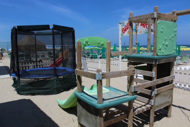 Scivolo e tappeto elastico in un'area giochi sulla spiaggia.