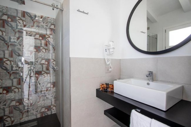 Bagno con doccia e lavabo design.