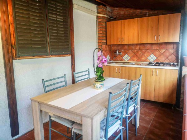 Tavolo e sedie in una cucina rustica.
