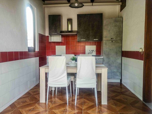 Cucina con tavolo e due sedie bianche.