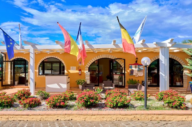 Edificio con bandiere e giardino fiorito.