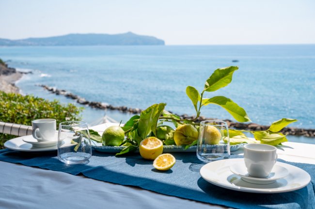 Tavola con limoni e vista mare.