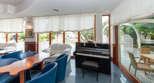 Interno elegante con pianoforte e poltrone.