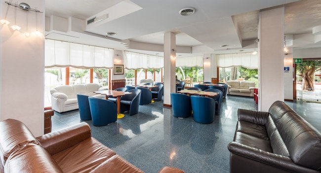 Sala luminosa con poltrone blu e divani.