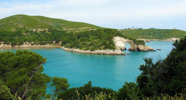 Baia con acqua turchese e scogliera.