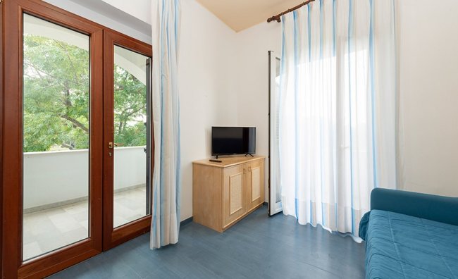 Soggiorno con porta finestra e tende a righe.