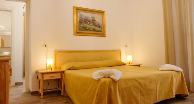 Camera da letto con letto matrimoniale e quadro.