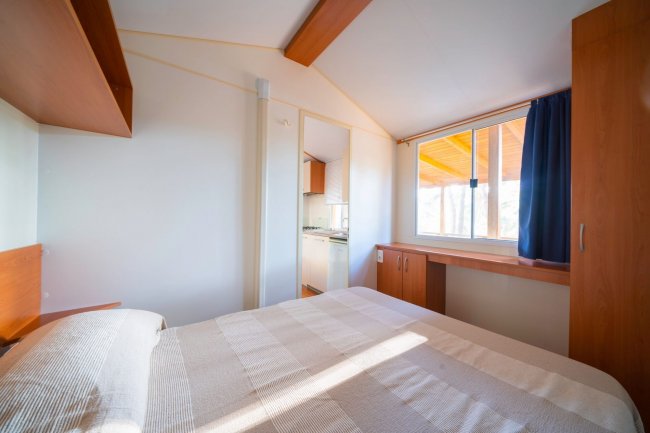 Camera con letto matrimoniale e finestra luminosa.