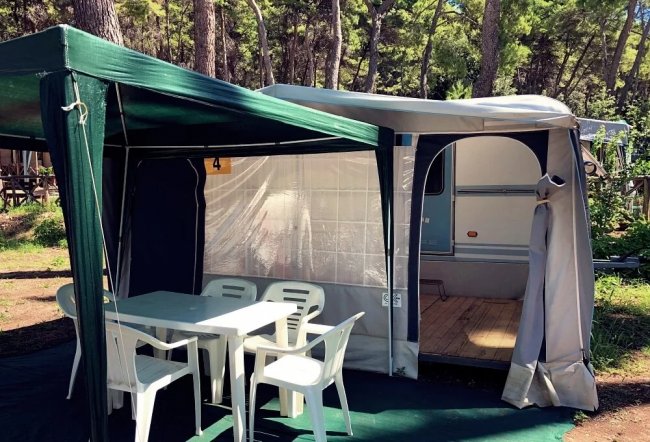 Una tenda attrezzata con tavolo e sedie.