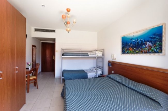 Camera con letto matrimoniale, letto a castello e scrivania.