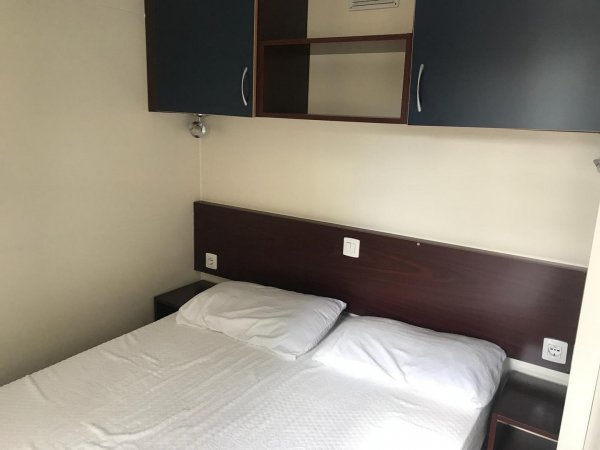 Letto matrimoniale con armadietto sopra.