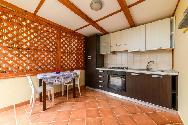 Cucina con tavolo e sedie, grata in legno.