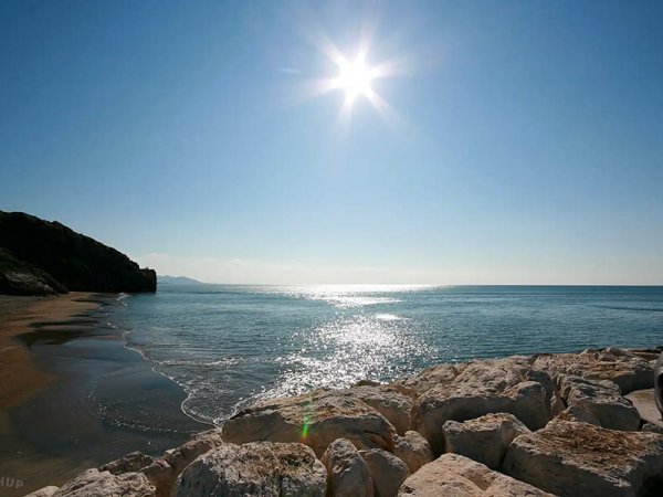 Spiaggia deserta con sole splendente.