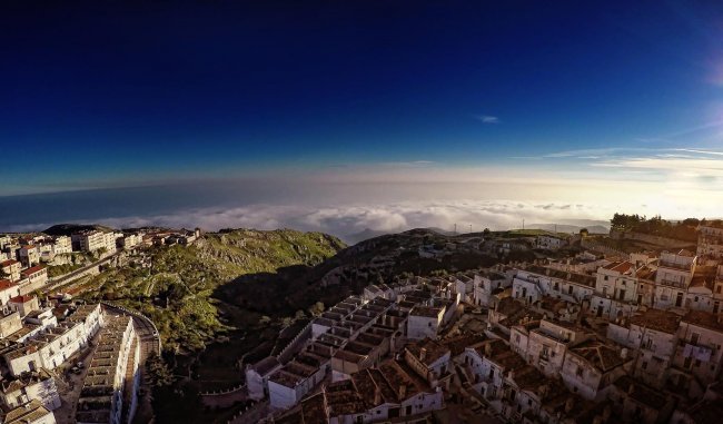 Panoramica di un borgo montano e nuvole.