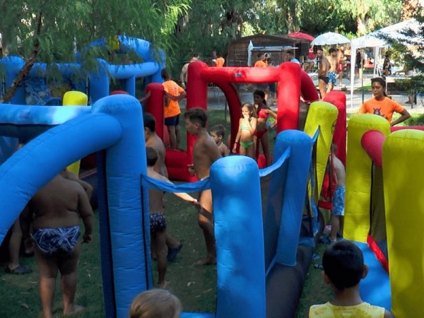 Bambini giocano in un labirinto gonfiabile colorato all'aperto.