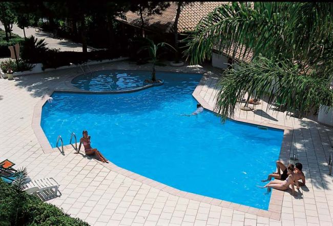 Piscina a forma irregolare con persone rilassate.