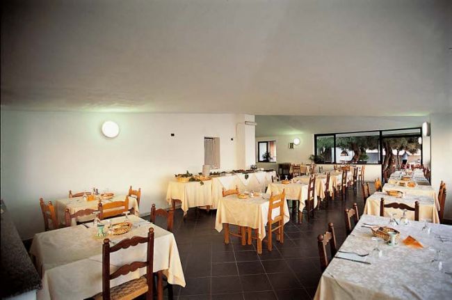 Sala da pranzo vuota con tavoli apparecchiati.