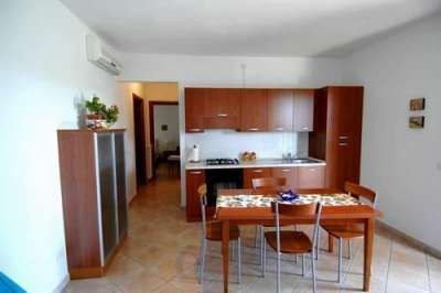 Cucina moderna con tavolo e sedie in legno.