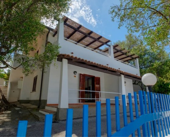 Casa bianca con terrazza e staccionata blu.