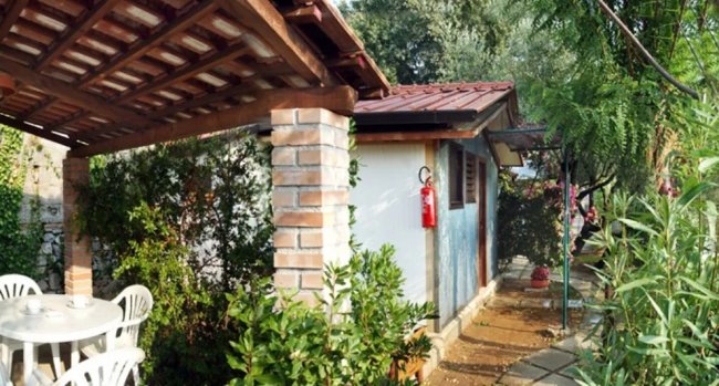 Veranda con tavolo bianco e casetta.