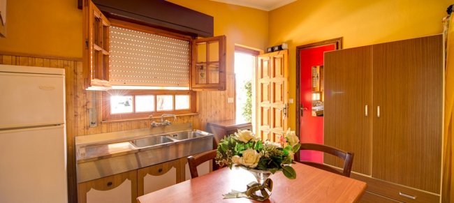 Cucina luminosa con tavolo e fiori freschi.