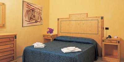 Una camera da letto con letto matrimoniale, copriletto blu e mobili in legno.