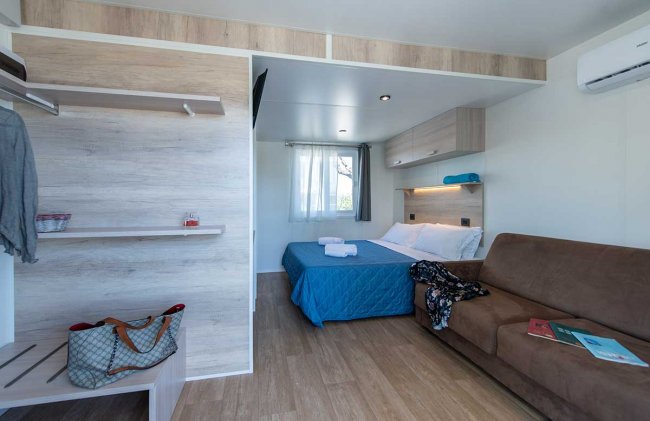 Camera con letto matrimoniale e divano marrone.