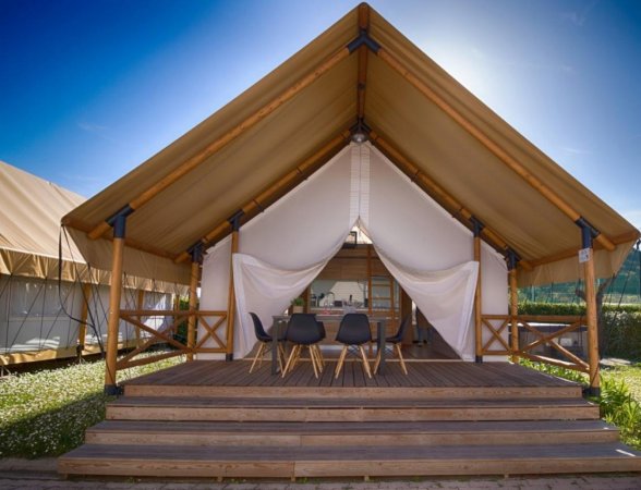 Tent lodge con sedie su terrazza.