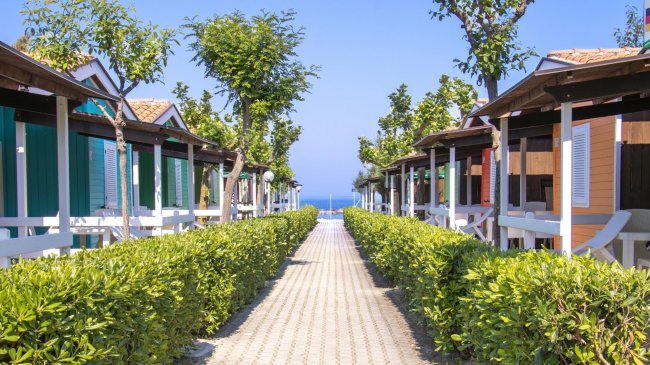 Sentiero tra bungalow con vista mare.